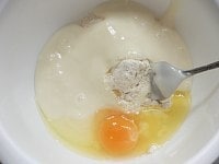 ボウルにホットケーキミックスを入れ、餅と卵を入れ、スプーンかヘラで混ぜる。