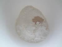 ボウルに強力粉、イースト、砂糖、塩、ベーキングパウダーを入れざっくりと混ぜます。この時、塩とイーストは隣接しないように気をつけましょう。<br />