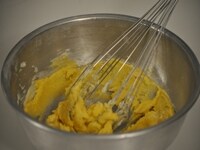 ボウルに、室温に戻したバターとグラニュー糖を入れ、混ぜ合わせ、卵黄を入れて、さらによく混ぜる。<br />