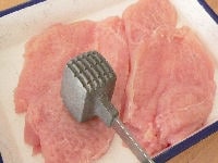鶏肉は皮を除き、中央に包丁で切り込みを入れて観音開きにして厚みを揃え、肉たたきなどでたたいて1センチ弱の厚さにします。たたいた鶏肉を半分に切ります。