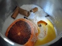 手鍋に、グラニュー糖、レモンの皮、厚めのオレンジのスライス、クローブ、シナモン、ナツメグを入れる。<br />
<br />