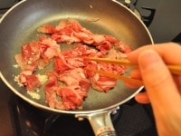 フライパンにサラダ油小さじ1/2（分量外）をひき、まずみじん切りにしたにんにくを軽く炒めます。<br />
<br />
香りが出てきたらすぐに牛肉を加え、8割がた炒めます。