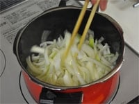 たまねぎとニンニクはうす切りにします。圧力鍋にバターを入れ中火にかけます。野菜がしんなりとするまで炒めます。<br />