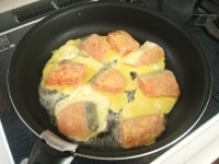 フライパンを熱し加塩バターとサラダ油をひきます。鮭を並べて片面がきつね色になるまで2分ほど焼きます。<br />