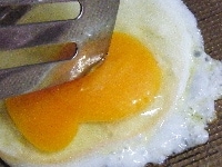 卵の白身が固まったら、黄身をつぶしてひっくりかえす