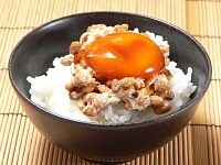 ご飯の上に、箸で混ぜた納豆をかけて、卵黄の醤油漬けをのせ、漬け汁をかける。