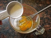 ときほぐした卵にグラニュー糖大さじ2を加え、グラニュー糖のざらざらがなくなるまでよく混ぜます。さらに牛乳、バニラエッセンスを加えてよく混ぜます。