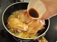 鶏肉にしっかり火が通った頃合いを見計らって、濃口醤油、みりん、日本酒の調味料をフライパンに加えます。火加減は中火から少し弱めた状態のまま、2分程度肉の上下を裏返しながら、肉に調味料を絡ませます。