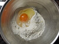 ボウルにそば粉、塩、卵を入れ、ゴムべらで全体をざっと混ぜます。<br />
