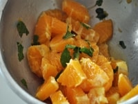 1のオレンジに塩をふり、オリーブオイルをかけ回して10分位寝かせて、手でちぎったミントの葉を混ぜ合わせて皿に盛る。