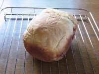 食パンコースで焼き上げる。焼き上がったら、2分ほどおいて、容器からパンを網に取り出して冷ます。<br />