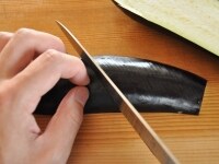 なすは縦半分に切り、皮に斜めに切り込みを入れます。そうすることで、食べるときに箸で皮が簡単に割け、食べやすくなります。