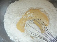 粉の真ん中に（2）の液を2/3ほど入れ、液体に粉を取り込むように混ぜ、残りを入れて混ぜる。