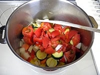 次にたまねぎ、ズッキーニ、パプリカを加え野菜に油が回ったらトマトを加えます。