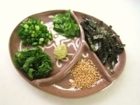 皿に薬味の野菜を盛り付け、他にわさび、きざみ海苔、白ごまを添えます。