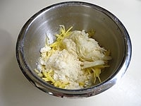 たまねぎの水気を絞り、ジャガイモのボウルに入れます。粉チーズ、塩、こしょうを入れ混ぜ合わせます。