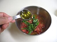 マリネ液を作ります。トマトは皮を剥き、5mm角に切ります。バジルは千切りにします。ボウルにトマト、バジル、レモン汁、オリーブオイルを加えます。