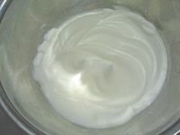 卵白に分量の半量の砂糖を加え、泡だて器で攪拌し、固いメレンゲを作ります。