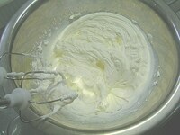 生クリームに残りの砂糖を加え、泡だて器で混ぜ、角が立つまで混ぜ合わせます。