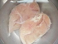 ボウルにたっぷり水を張り、水で洗った鶏肉を入れ、2回ほど水を変えながら2時間ほど浸けて余分な塩を抜く。鶏肉の端を少し切って、電子レンジで加熱して食べてみて、ちょうどよい塩味になってるか確かめる。