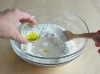 ボウルに強力粉、薄力粉、砂糖、塩、ブラックペッパーを入れ、水で溶いたインスタントドライイースト、オリーブオイルを入れ、スプーンで混ぜる。<br />