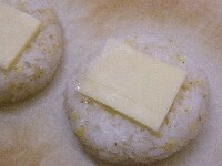 ラップを外してクッキングシート又はアルミホイルの上にのせ、小さめに切ったチーズをおにぎりの上にのせる
