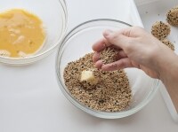 キッチンペーパーで水気をよくふきとり、小麦粉をまんべんなくまぶした里芋を、フライの要領で、溶き卵にくぐらせて胡麻衣をつける。