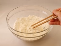 ボウルに強力粉・薄力粉・塩をいれて混ぜ合わせ、40度位のぬるま湯を加える。初めは箸でかき混ぜ、大体混ざったら手でこねる。<br />