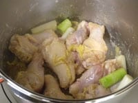 圧力鍋にゴマ油を入れ、中火にかけます。ねぎ、生姜、鶏肉を加えてさっと炒めます。