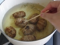 鍋にオリーブオイル、ローズマリー、タイムを入れて70度まで熱し、里芋を入れて温度を保ったまま40分～1時間火にかける。竹串がすっと通るくらい柔らかくなったらOK。