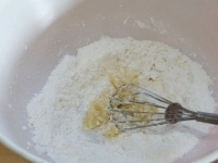 小麦粉と粉砂糖をボールに入れ、泡たて器で混ぜてダマをなくす。<br />