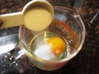 卵にグラニュー糖を加え、よく混ぜます。さらに残りの牛乳を加え、全体をよく混ぜます。