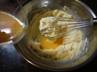 解きほぐしておいた卵を2～3回に分けて加え、そのつど、泡立て器でよく混ぜます。分離しないよう、必ず、室温に戻したものを使いましょう。