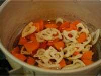 鍋ににんじんとレンコン、水・めんつゆを加え、落し蓋をして5分ほど煮ます。