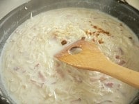 牛乳を加え、スープの素を砕いて入れ、木ベラで混ぜながら4～5分煮詰める。<br />