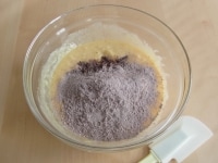 ふるった１の粉類の半量も加え、ホイッパーからゴムベラに持ち替え、底から生地をすくい上げるようにして、全体にざっくり混ぜる。