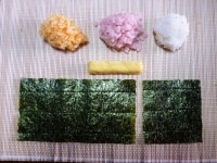 <div>材料を揃えます。</div>
<div>40ｇの寿司飯2個にそれぞれ、<br />
とびこ10ｇ、おぼろ10ｇを混ぜ込み、<br />
オレンジ、ピンク、白の寿司飯を各50ｇ用意します。<br />
海苔1/2と1/4　厚焼き玉子も用意します。</div>