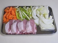 豚バラ肉の塊は、塩麹大さじ1をすり込み、冷蔵庫で6時間以上漬けておきます。肉の表面を軽くふき取り4等分に切ります。玉ねぎはうす切りに。ニンジンは1cm巾のうす切りに、セロリも5cm長さの縦にうす切りにします。<br />