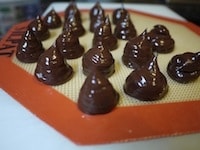 チョコレートが冷えて絞れる固さになったら、オーブンペーパー、またはシリコンパッドの上に、直径2cmほどの大きさに絞り出します。その後、冷蔵庫で冷やし固めます。