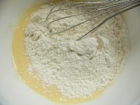 ボウルに卵を入れて泡だて器で混ぜ、ヨーグルトを入れて混ぜ、ミックス粉を入れて混ぜる（全てグルグル混ぜるだけ）。<br />