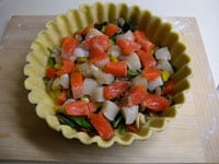 生地型に炒めた野菜類を入れて、上から魚介類を彩りよくのせます。