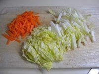白菜は縦半分に切り、短冊切りにします。にんじんは皮を剥き、白菜と同じように短冊切りにします。彩を考えてキュウリを加えても良いでしょう。<br />