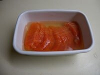 刺身用の鮭は斜め削ぎ切りにします。容器に入れ、ひたひたに被るまで酢を加え、30分ほど漬けておきます。