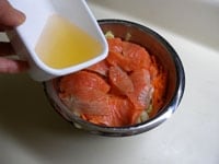 漬け込む容器に、短冊切りの野菜と、鮭は漬け汁ごと加えます。