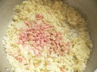 蒸してマッシュしたじゃが芋に、刻んだ玉ねぎとベーコンを入れて混ぜ、黒コショウを多めにふり、塩で調味して丸め、衣をつけて油で揚げる。<br />