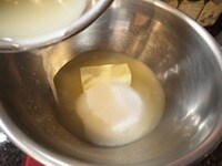 レモン果汁を絞り、バター、グラニュー糖をボウルに入れます。