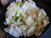 白菜はざく切りにする。フライパンにトウガラシの輪切りと、みじん切りのにんにくとしょうがを入れて強火にかけ、香りが出てきたら白菜と塩を入れて炒める。