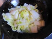 白菜がとろりとしてきたら、水と日本酒を足し、鍋を揺すって煮汁を乳化させながらさらに白菜が柔らかくなるまで炒める。