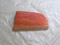 刺身用鮭の切り身に、塩と胡椒を振ります。<br />