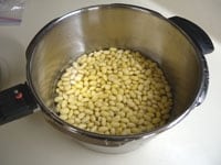 圧力鍋に戻し汁ごと大豆を入れます。圧力鍋では調理量を守ります。特に豆類は水分を含めて、圧力鍋の1/3ほどの量で煮ます。